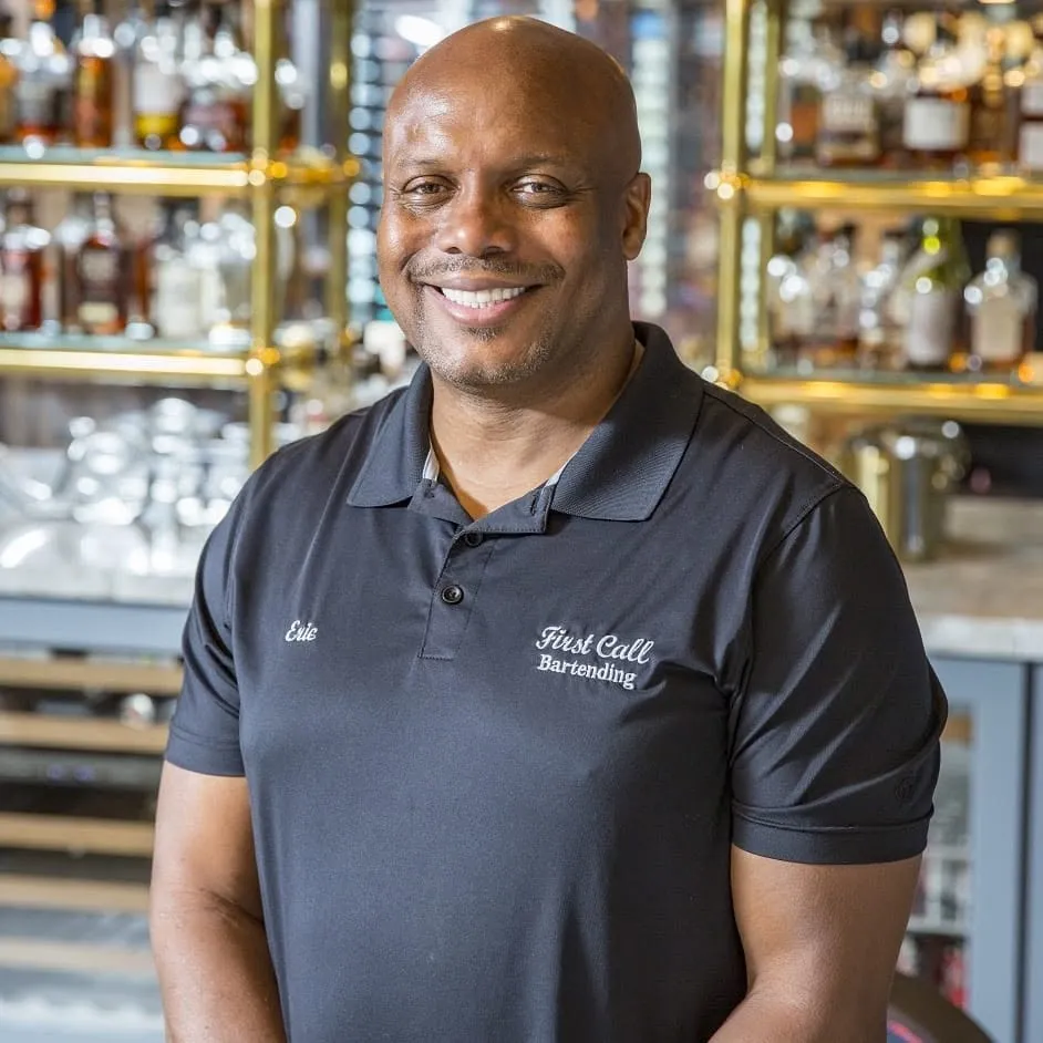 Founder Eric Chapman in a First Call Bartending polo in front of a back bar